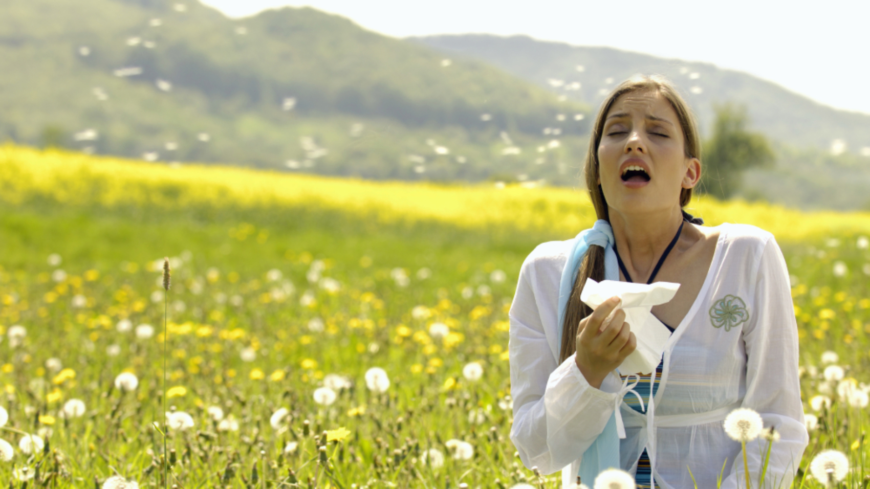 Woman,Sneezing,With,Tissue,In,Meadow