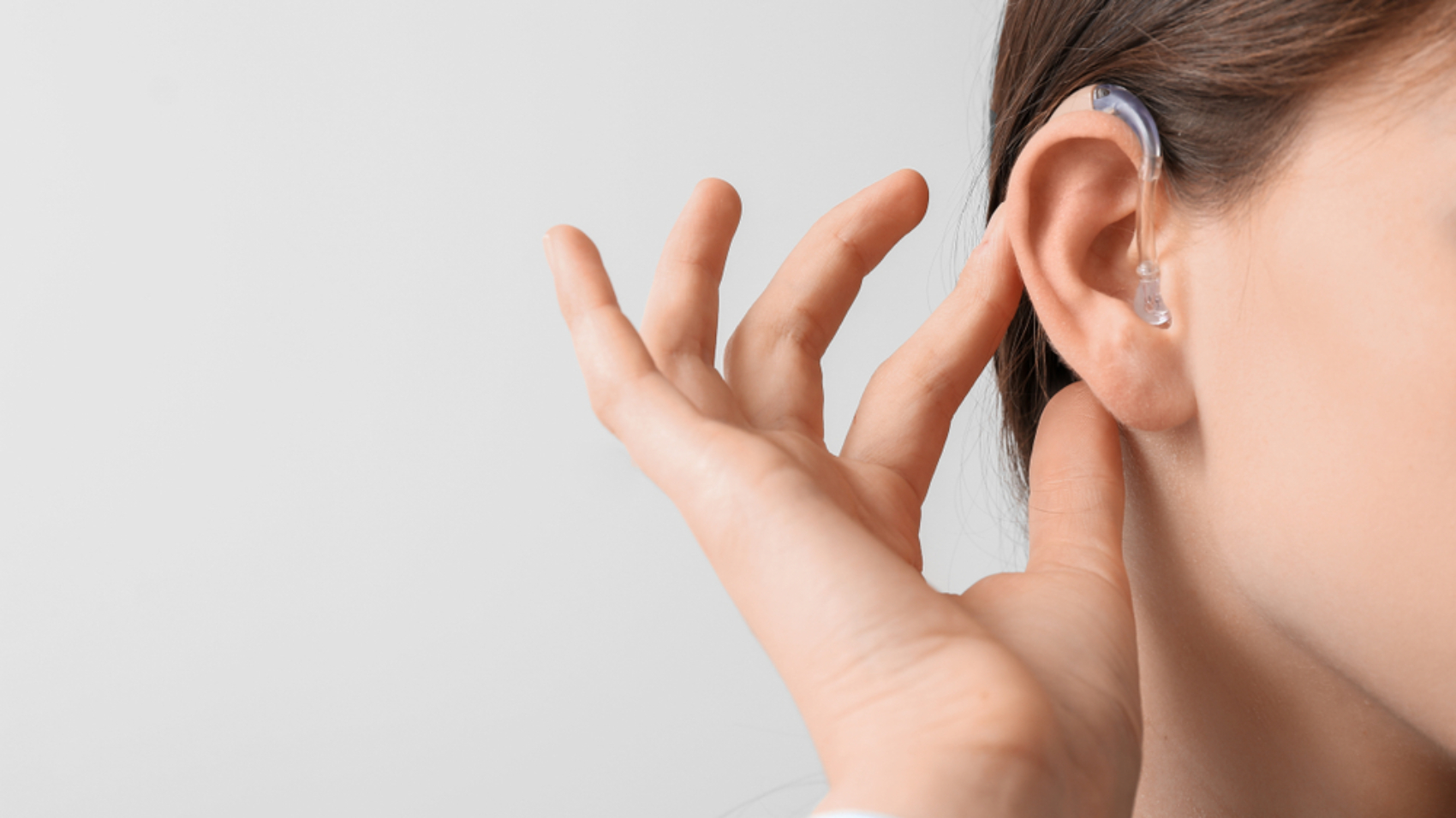 Young,Woman,With,Hearing,Aid,On,Light,Background