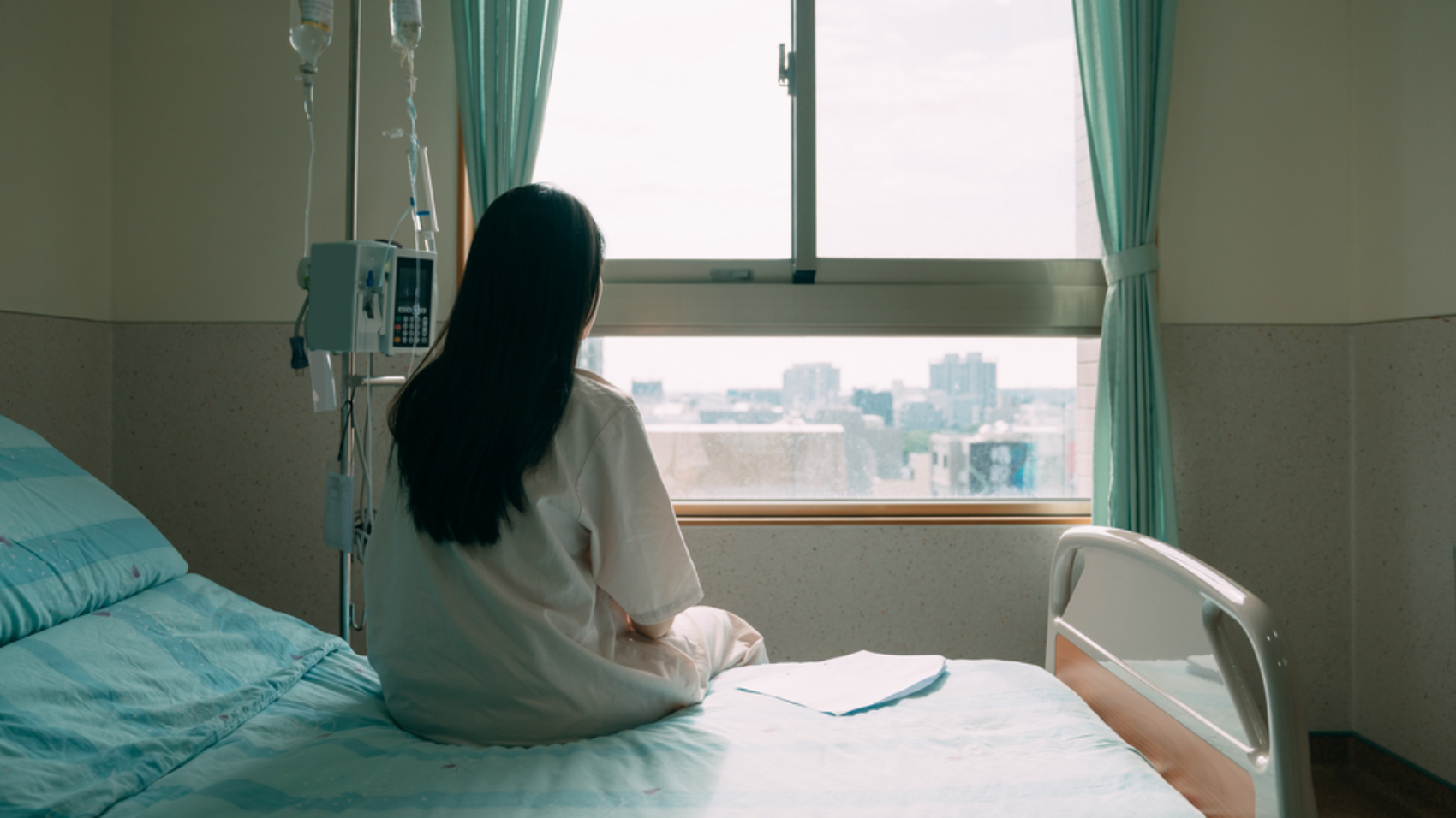 Back,View,Of,Lonely,Young,Asian,Woman,Sitting,On,Bed